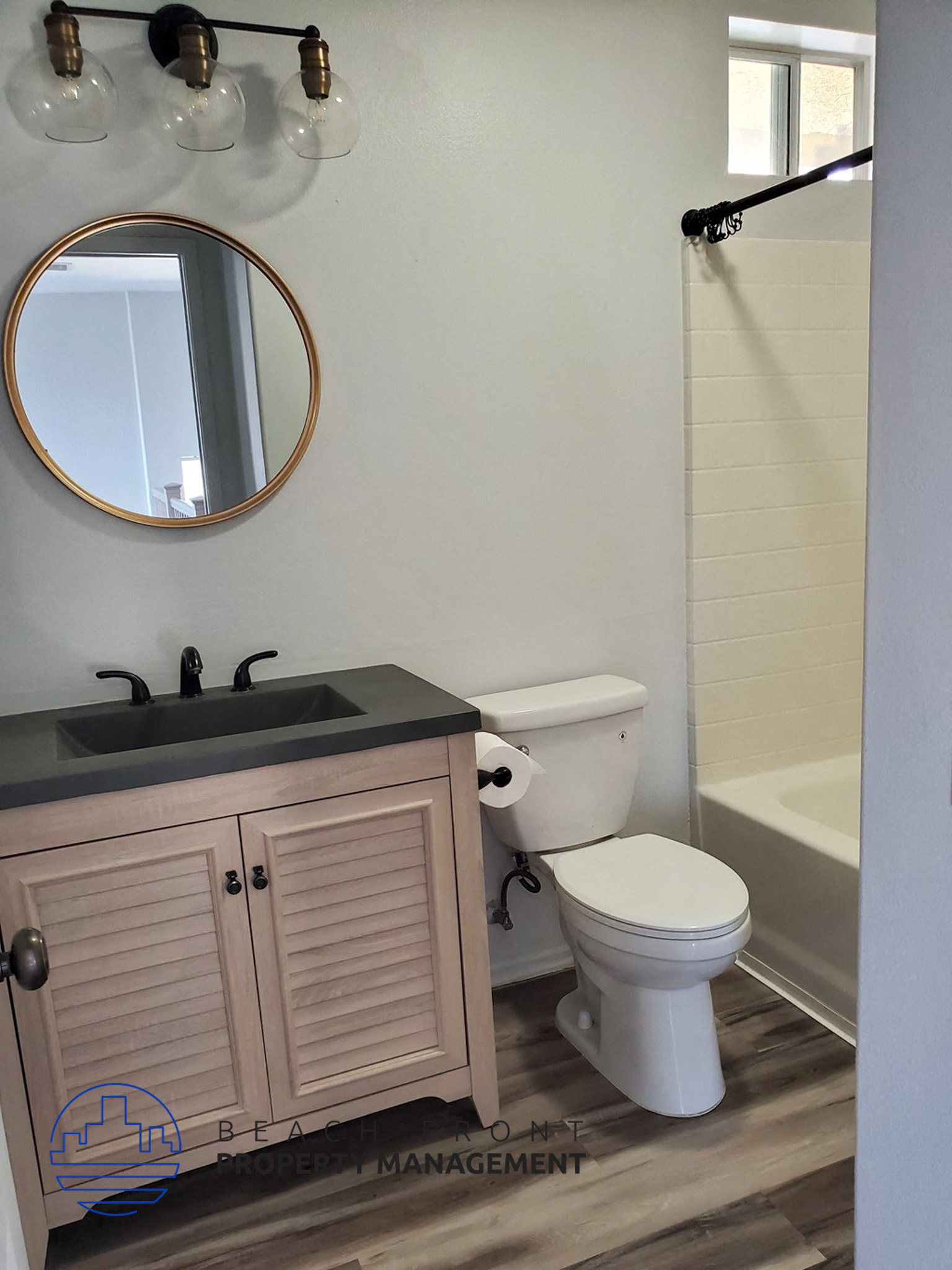 A bathroom with a sink, toilet, and a mirror.